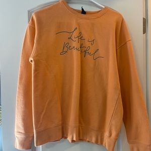 “life is beautiful” peachy/orange colored crew neck.
